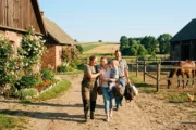 Gospodarz wita rodzinę gości na podwórzu polskiego gospodarstwa agroturystycznego - ubezpieczenie agroturystyki i OC rolnika