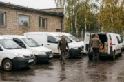 Firmowe auta dostawcze i osobowe zaparkowane na placu małej firmy o poranku - ubezpieczenie flotowe od ilu aut
