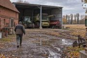 Obraz wygenerowany przez AI. Ciągnik i kombajn w wiacie na podwórzu gospodarstwa w Wielkopolsce po zbiorze kukurydzy, ubezpieczenie maszyn rolniczych na zimę